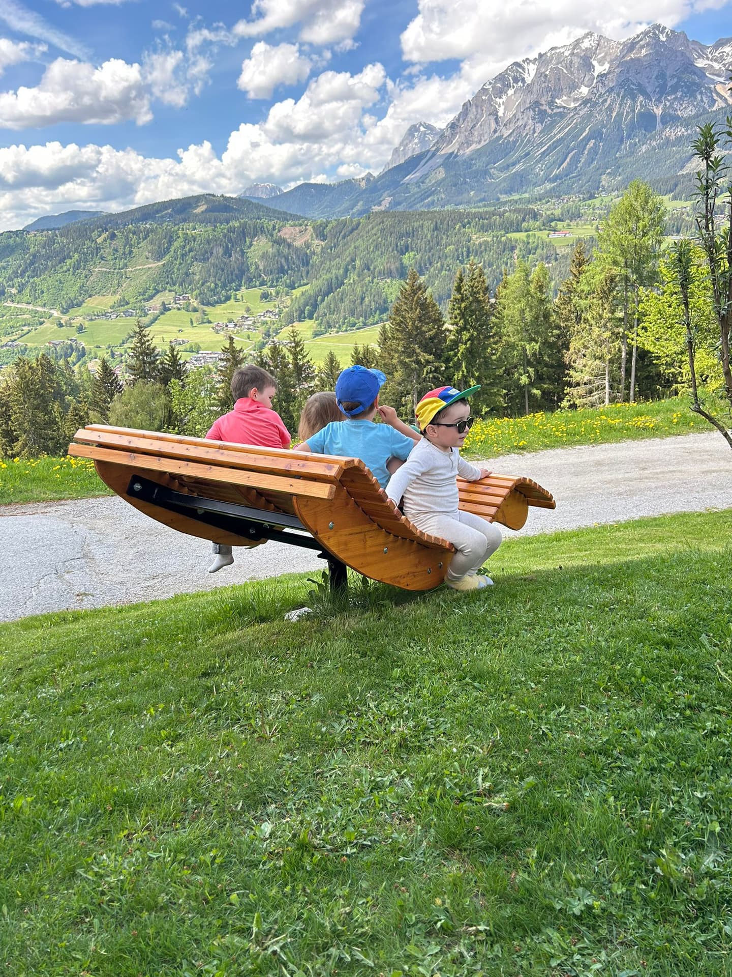 Familie auf einer Panoramabank mit Blick auf die Schladminger Berge