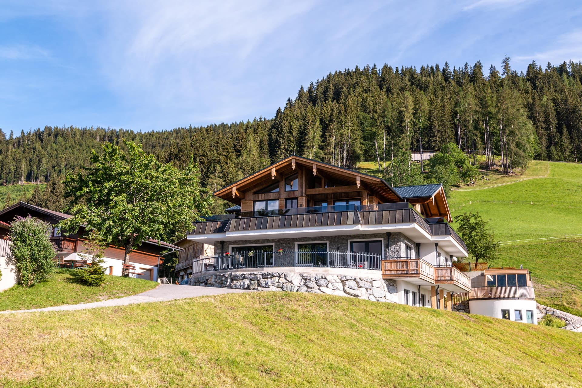 Bucheggerhof inmitten grüner Wiesen und bewaldeter Berge