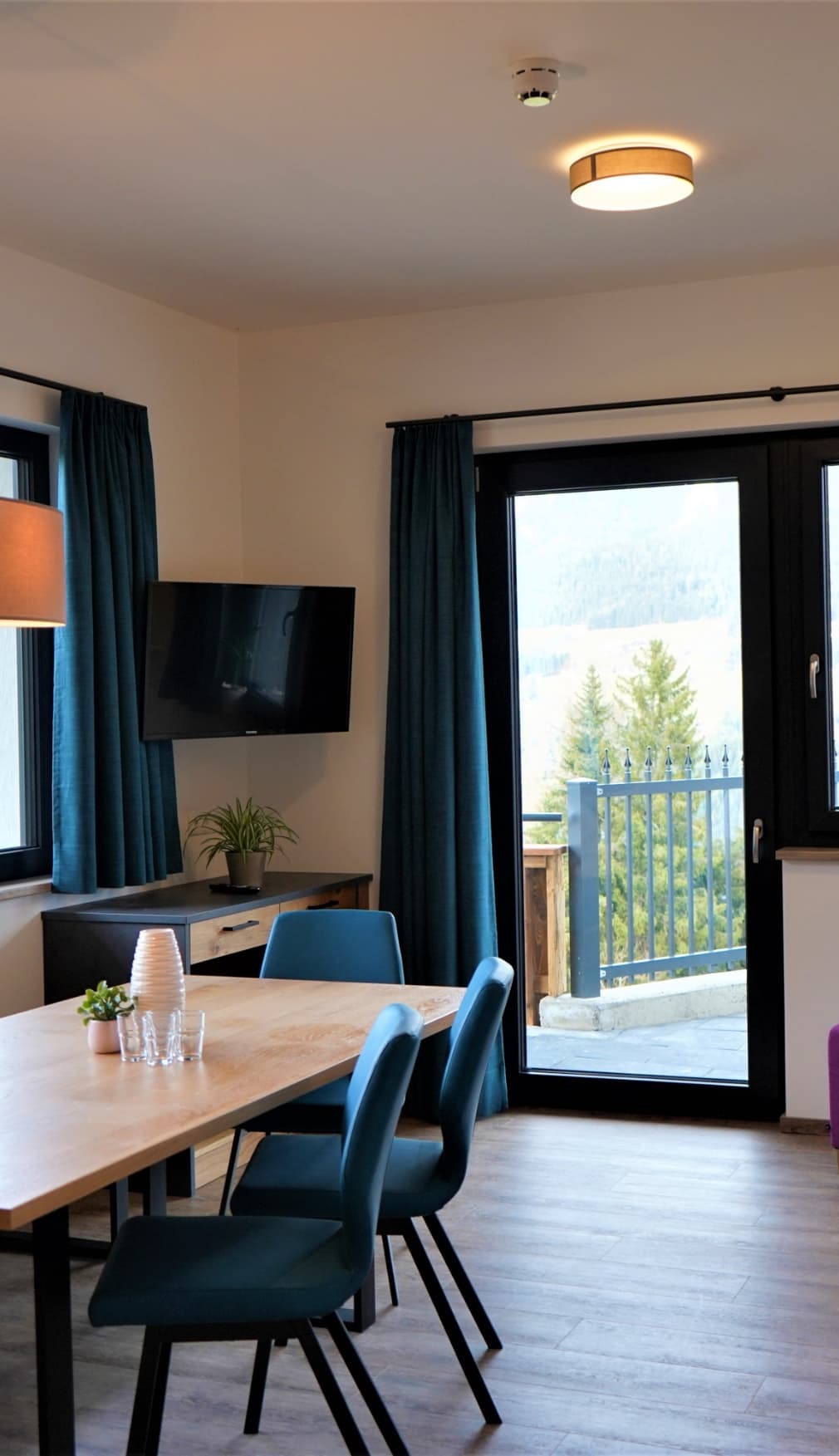 Wohnbereich mit TV und Balkonzugang im Apartment