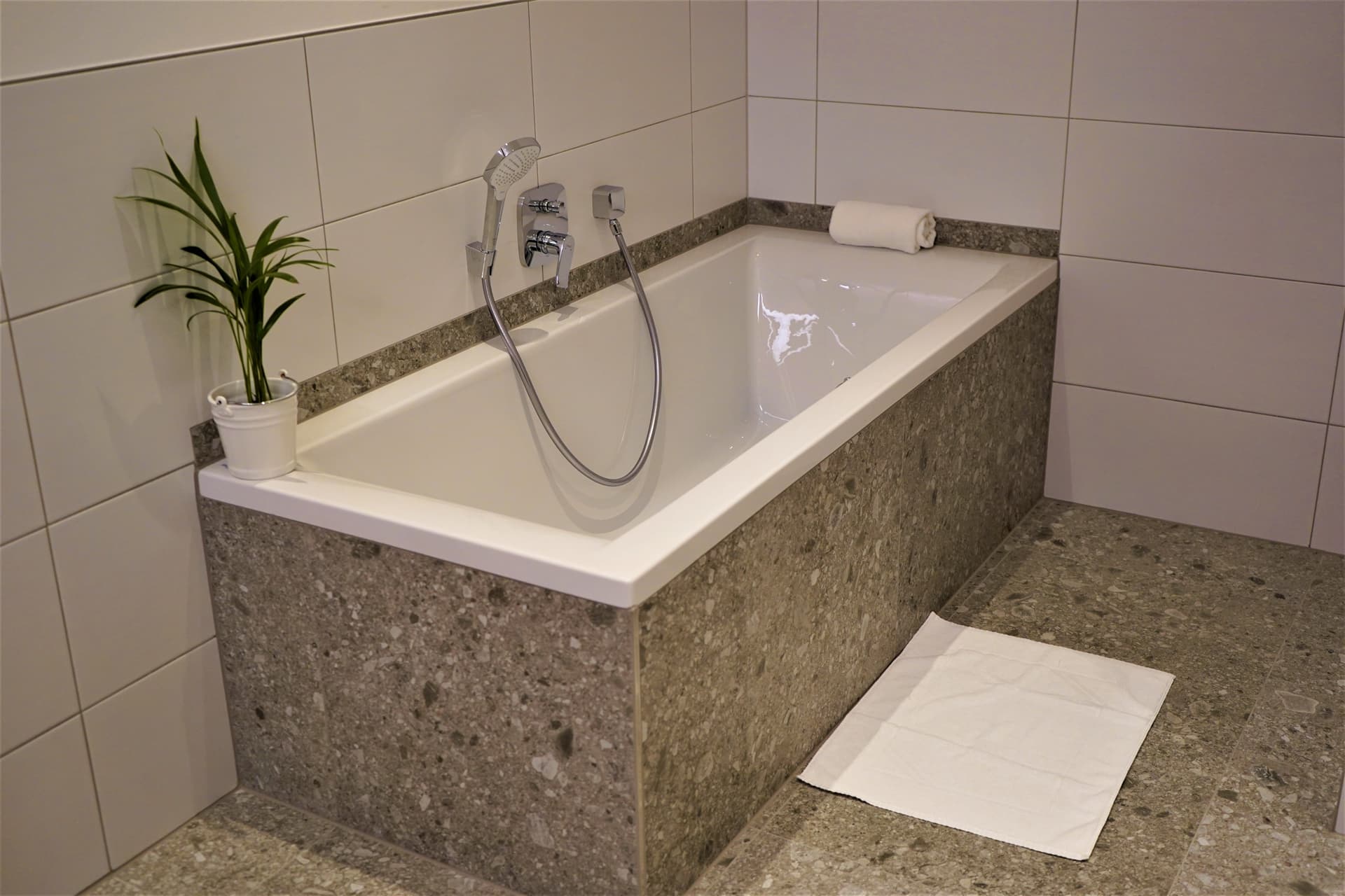 Badezimmer mit Badewanne und Natursteinverkleidung