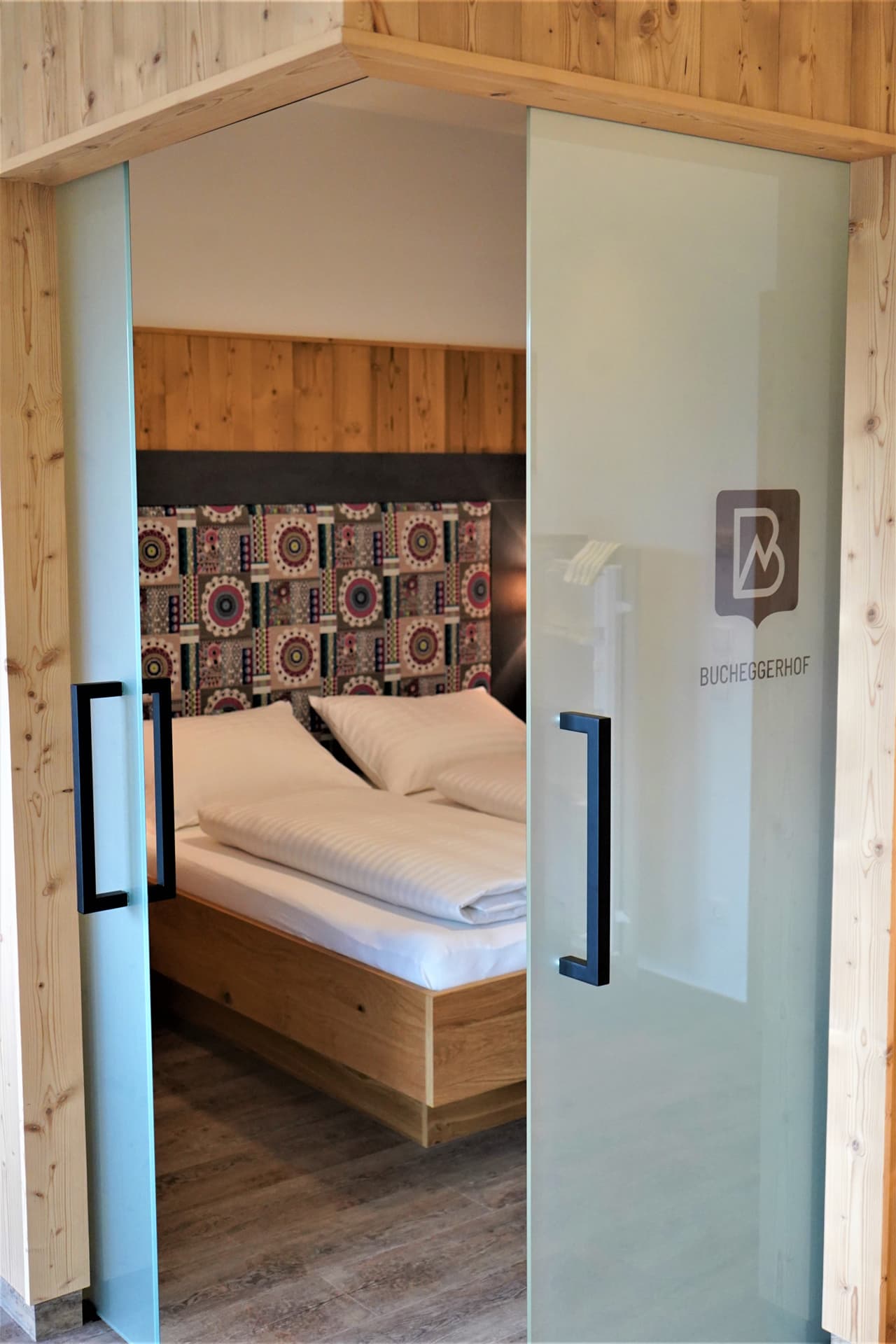 Blick durch die Glastür in ein gemütliches Schlafzimmer