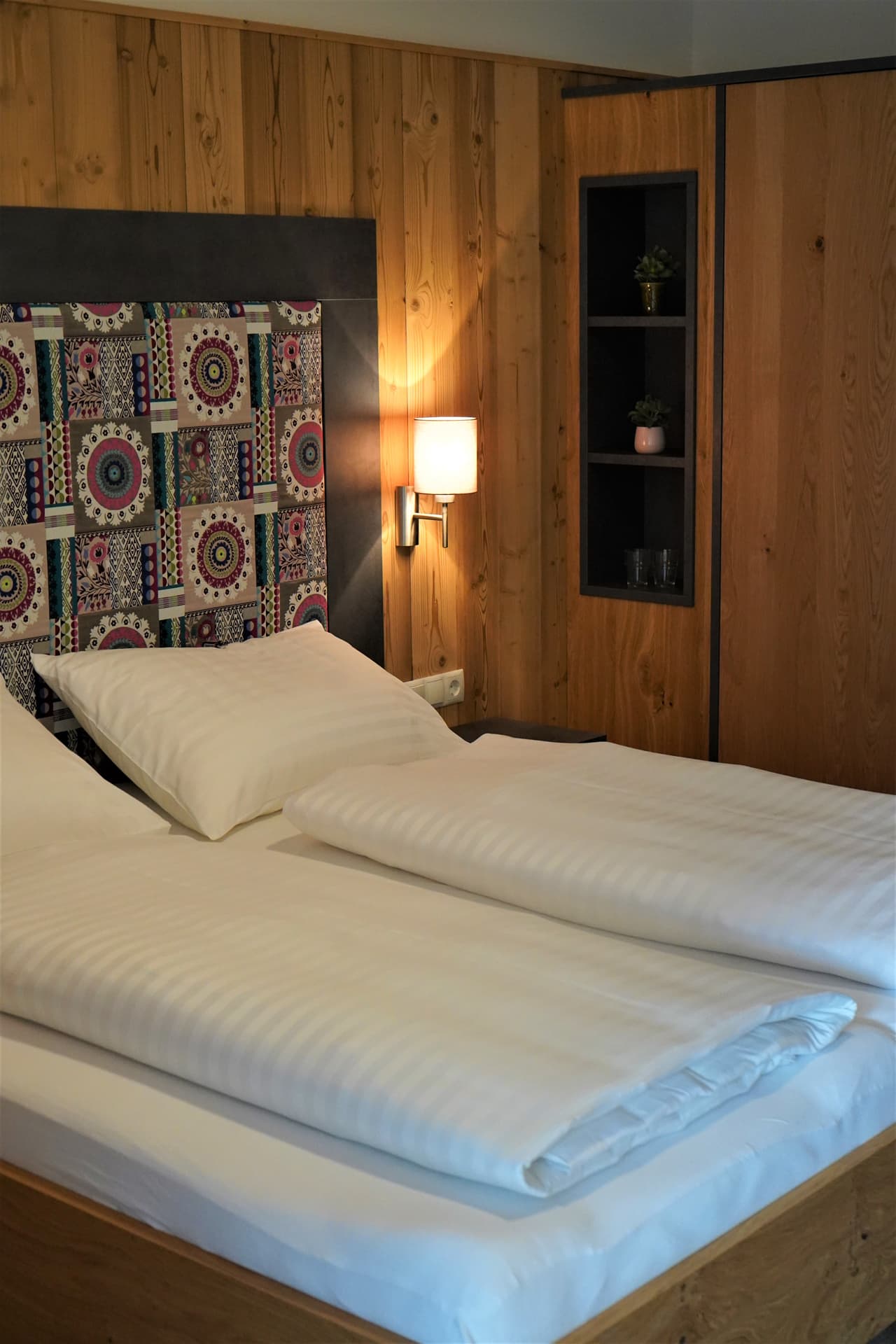 Gemütliches Doppelbett mit dekorativem Kopfteil im Schlafzimmer