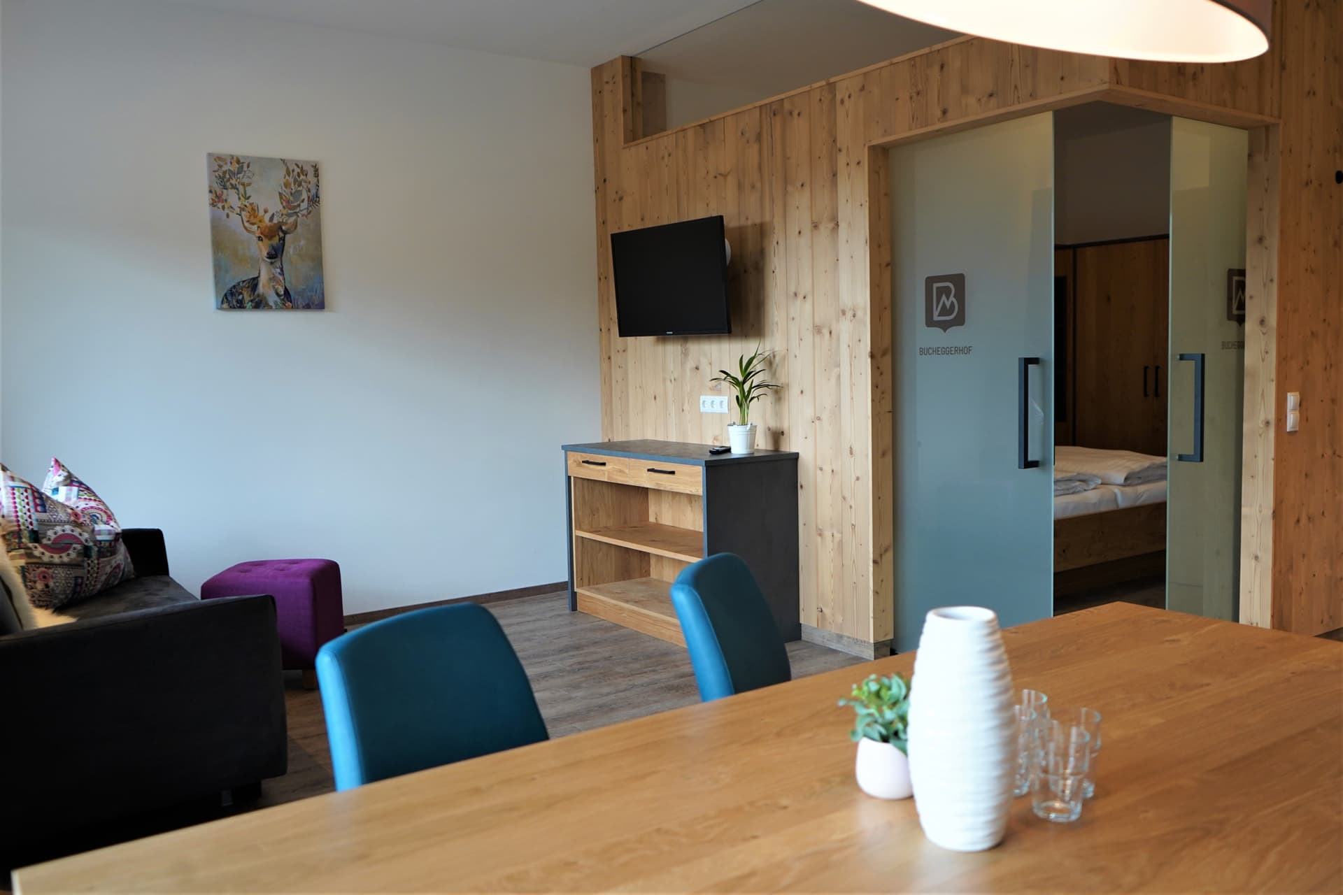 Wohnbereich mit TV und Holzmöbeln im Apartment