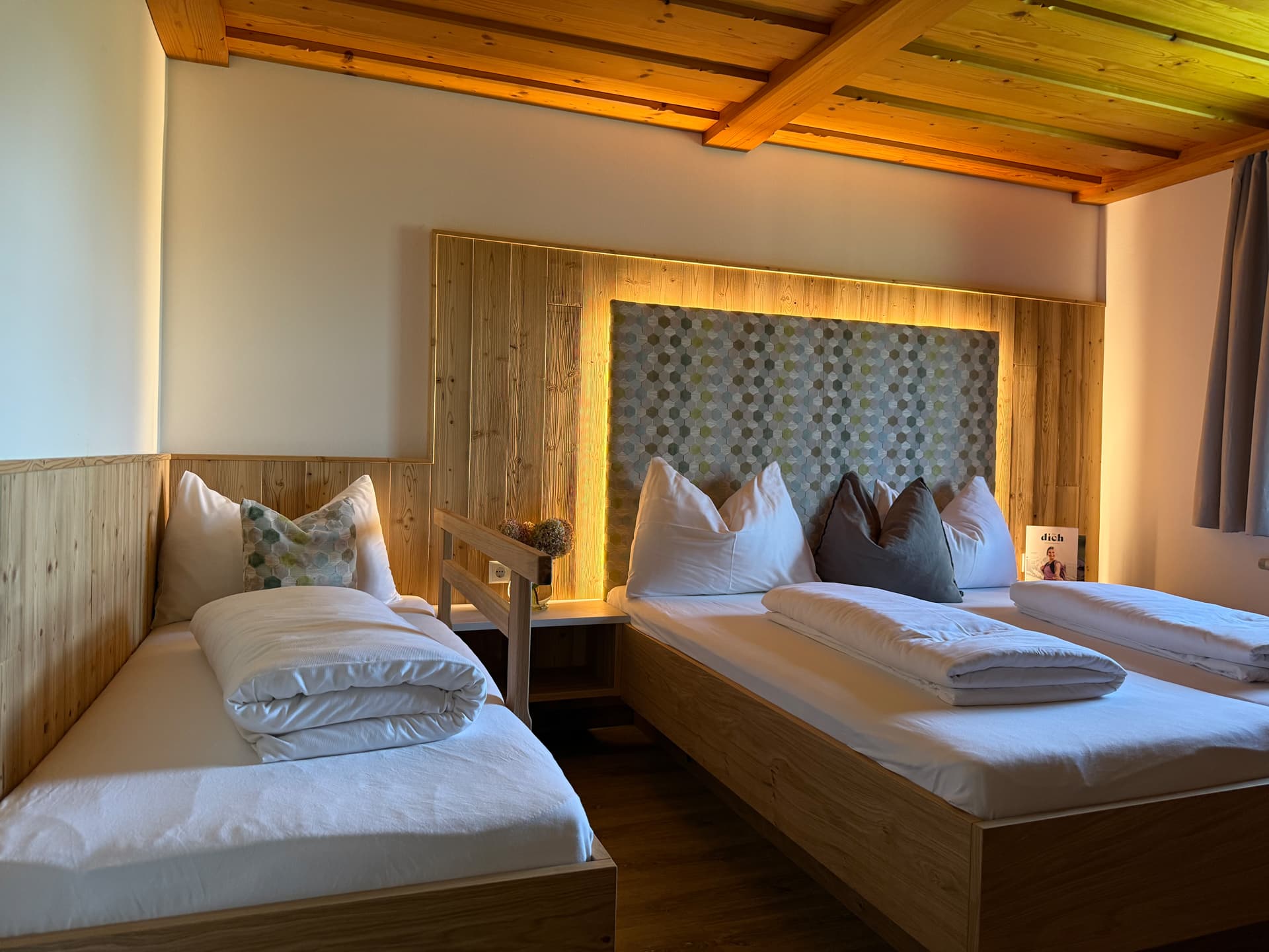 Schlafzimmer mit Doppelbett und Einzelbett in gemütlicher Holzoptik