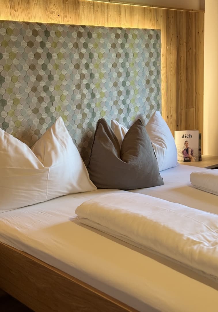 Doppelbett mit gepolstertem Kopfteil und Holzelementen
