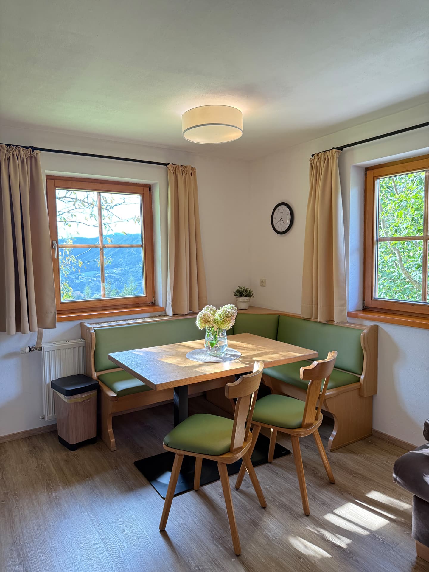 Gemütliche Sitzecke mit Esstisch und Fenstern im Apartment