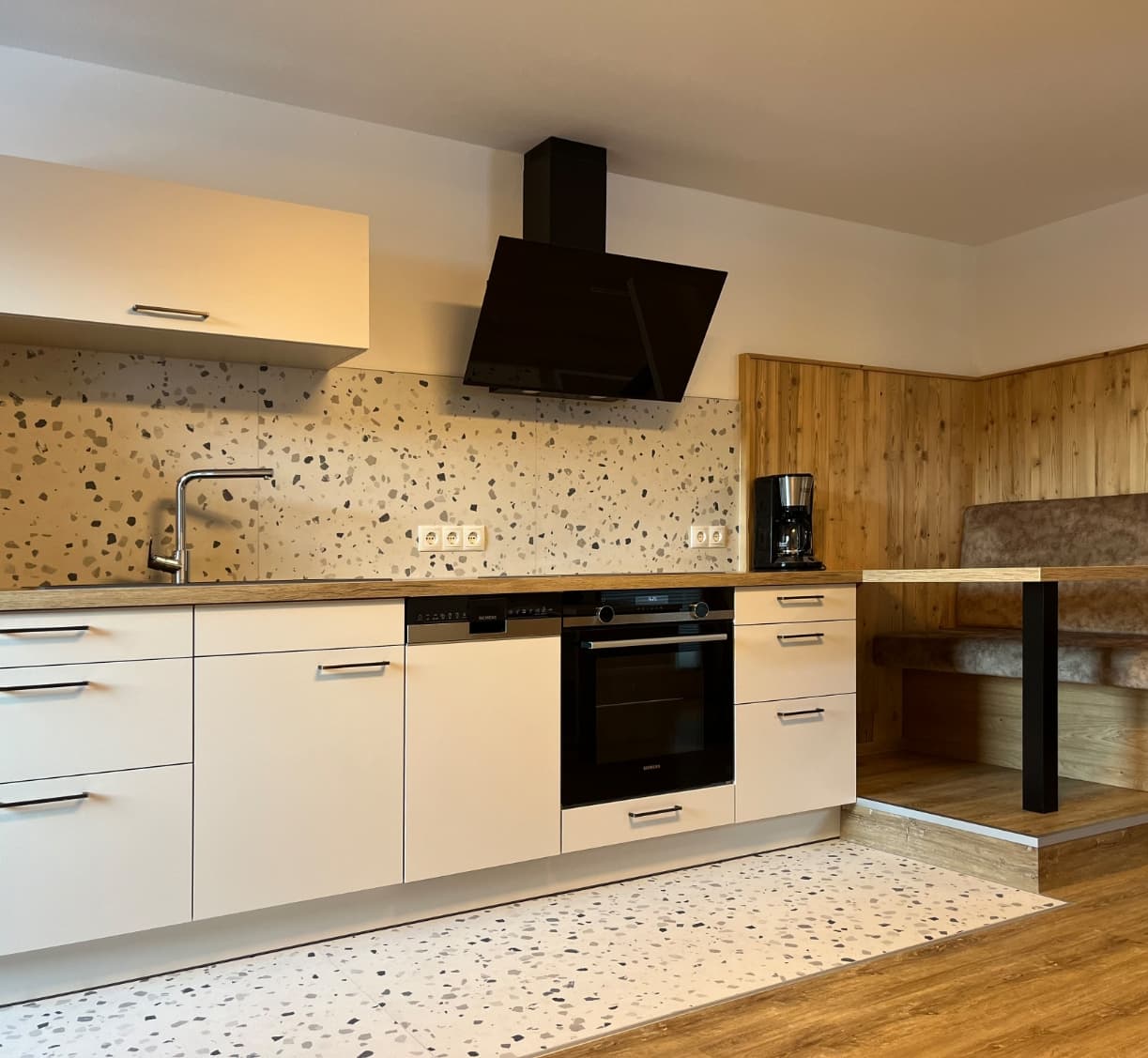 Moderne Küche mit Kochfeld und Dunstabzug im Apartment