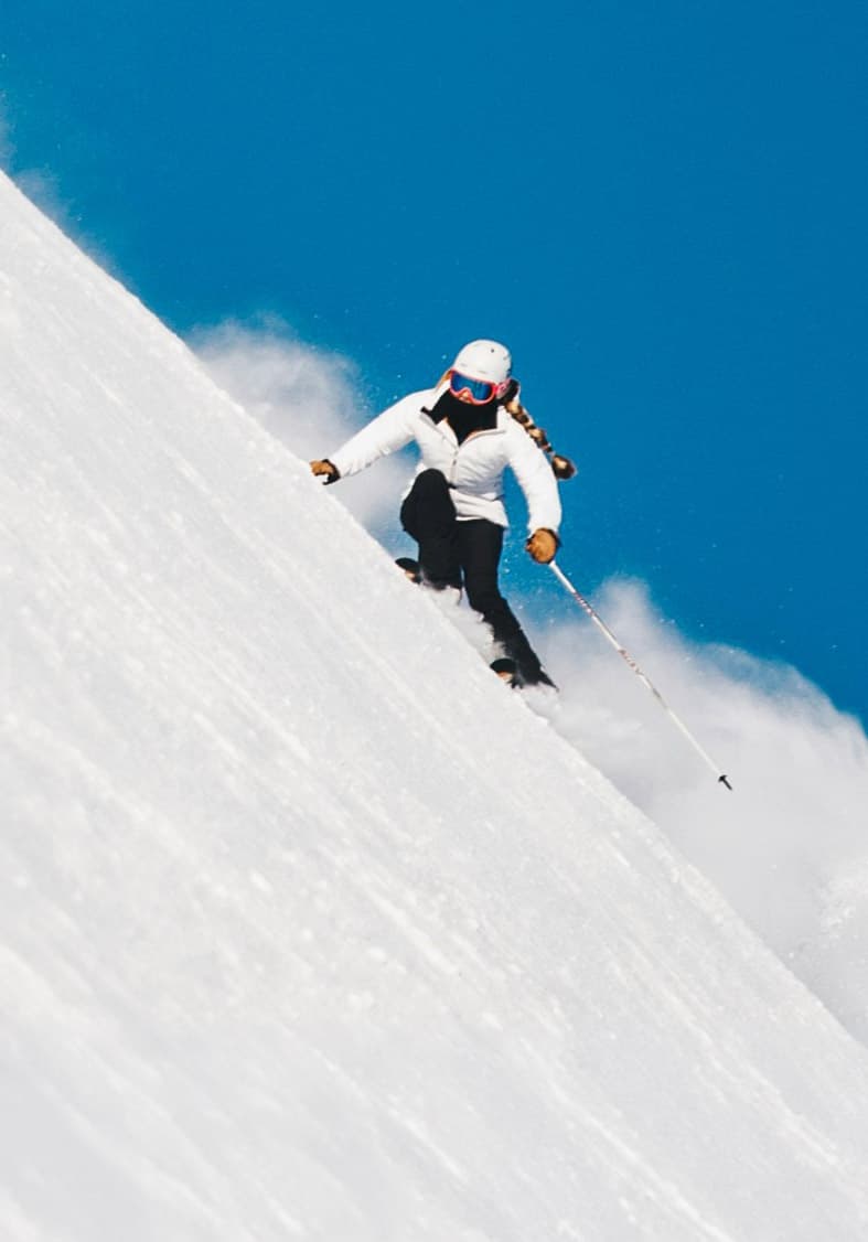 Skifahrer bei einer Abfahrt im Tiefschnee