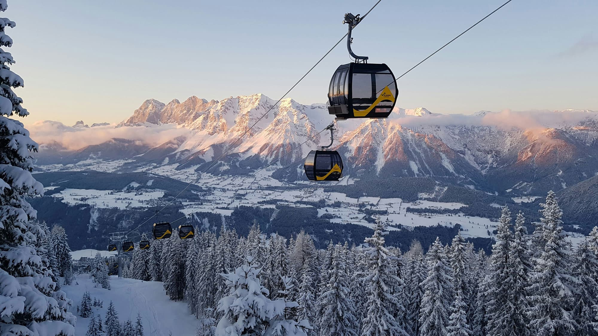 Gondelbahn vor verschneitem Bergpanorama in Schladming