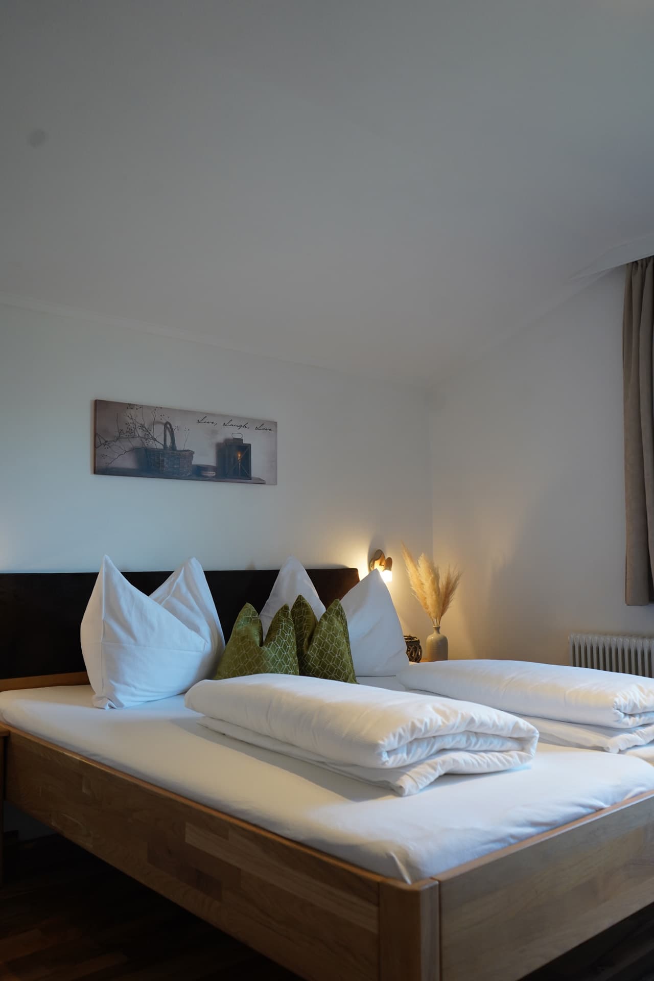 Helles Schlafzimmer mit Doppelbett und Wandbild