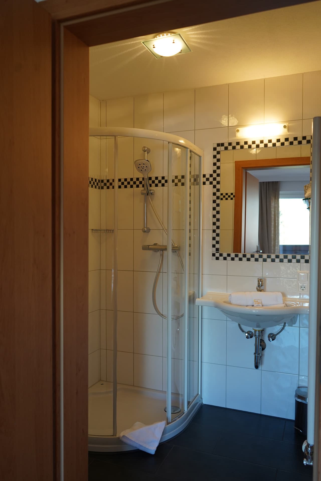 Badezimmer mit Dusche und Waschbecken im Apartment