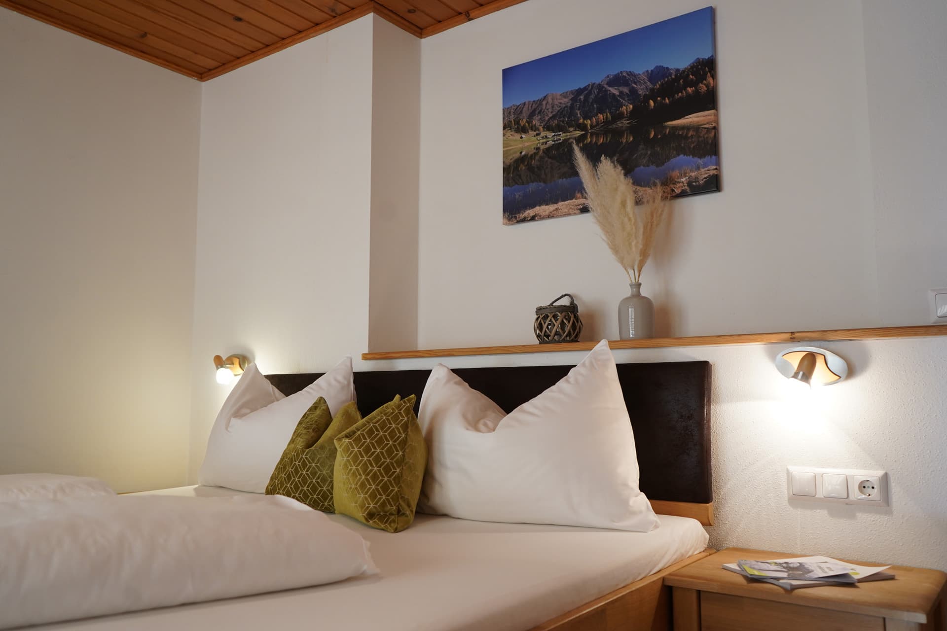 Doppelbett mit Holzelementen und Bergbild im Schlafzimmer