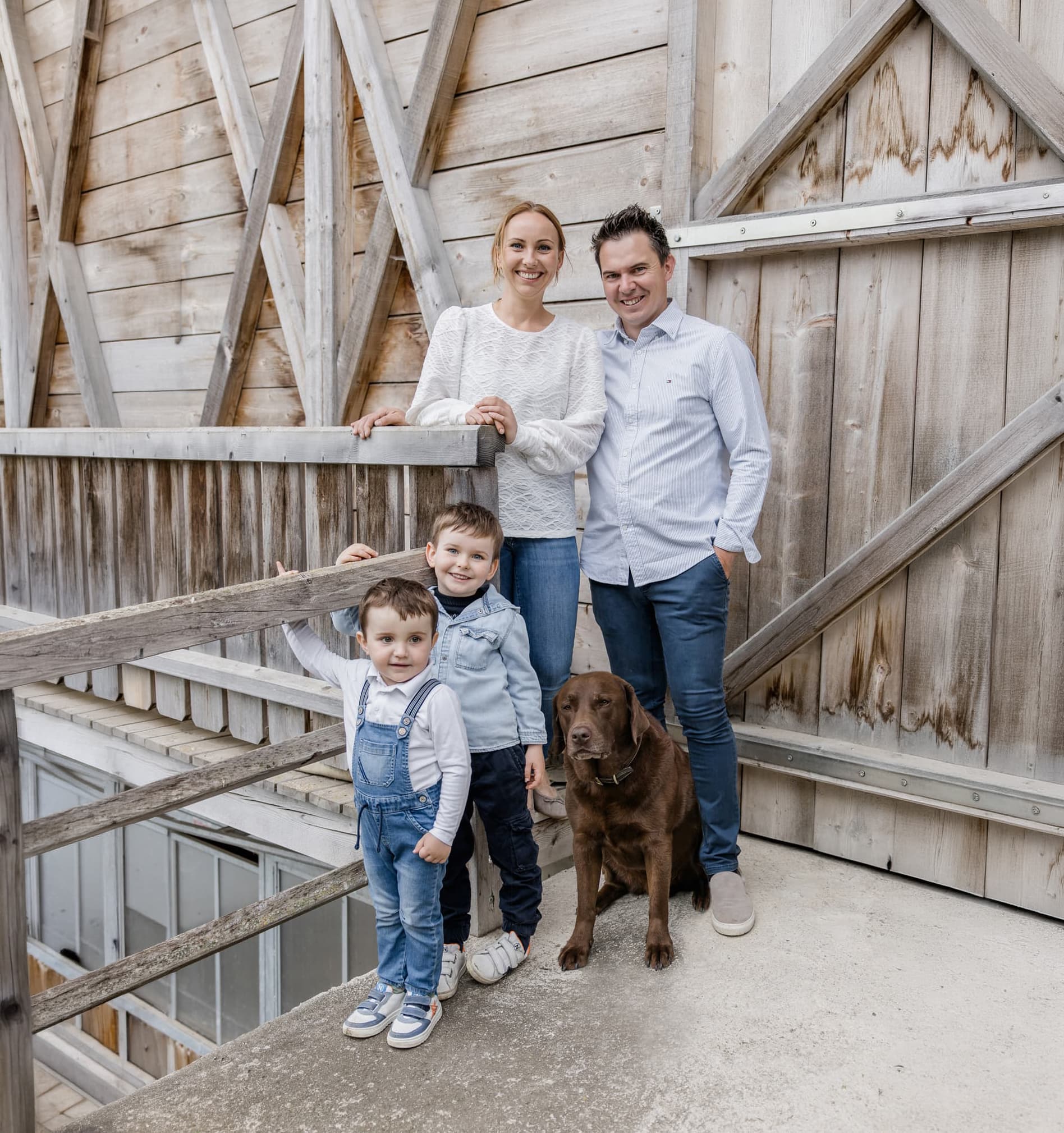 Gastgeberfamilie des Bucheggerhofs vor einer Holzhütte